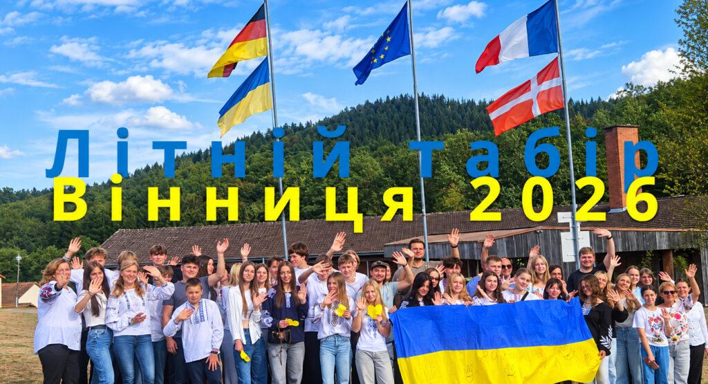 Le groupe de 35 jeunes ukrainiens de Winnyzja avec leurs accompagnateurs posant fièrement avec le drapeau ukrainien devant les drapeaux européen, français, allemand et alsacien à la JFBS Baerenthal.
